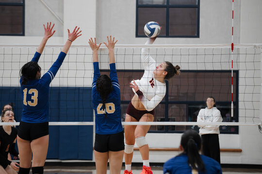 Volleyball outside hitter against a double block - Powered by Adobe
