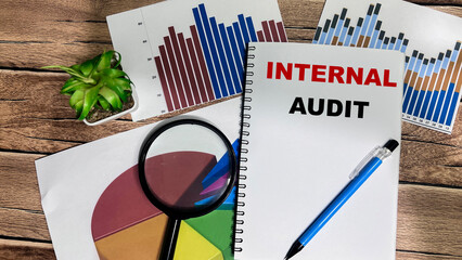Concept of Internal Audit write on book isolated on Wooden Table.