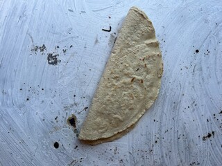 Empanada made with corn masa cooking on a comal in Oaxaca, Mexico