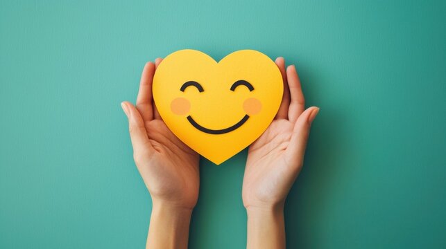paper cut smiley face in hands make heart symbol for protection around on green background. positive thinking, mental health, assessment, world mental health day concept - Powered by Adobe