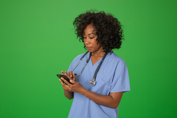 Black female nurse checking her message on mobile phone