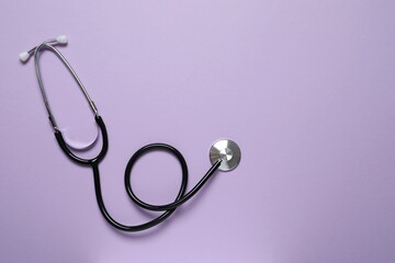 Stethoscope on color background, top view