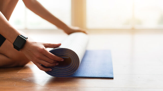 Healthy Lifestyle Concept. Close Up Profile Sive View Of Unrecognizable Lady Wearing Smartwatch Rolling Yoga Mat Practicing Pilates, Ready For Morning Routine Training. Wellness And Wellbeing