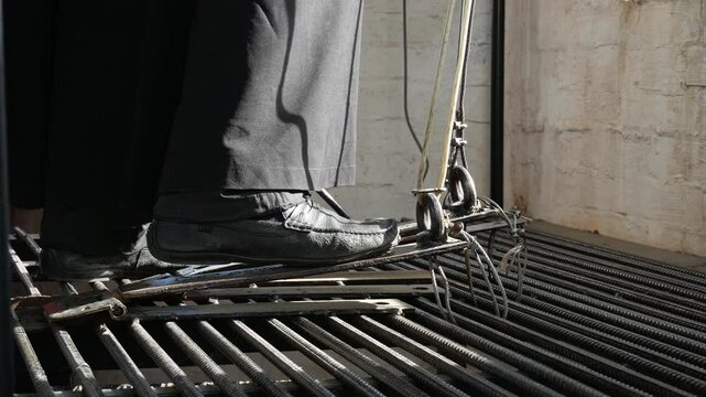 The ringing of bells in a Christian church. The bell ringer rings the bells of the Orthodox Church. A church minister presses the pedal with his foot to control the bells.