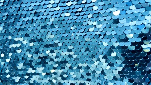 Blue sequin fabric with shimmering highlights luxurious textured background for design.Holiday abstract glitter texture with blinking lights,4K video