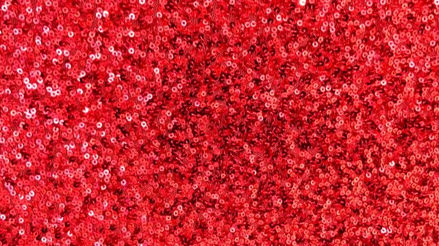 Red sequin fabric with shimmering highlights luxurious textured background for design.Holiday abstract glitter texture with blinking lights,4K video
