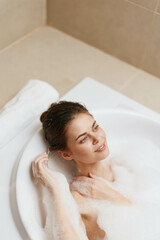 Relaxed young woman enjoying a bubble bath, surrounded by foam and soft lighting. Self-care and wellness concept for leisure and relaxation.