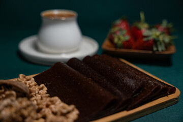 Delicious dessert in a wooden plate with walnuts, strawberries and traditional Turkish coffee on top
