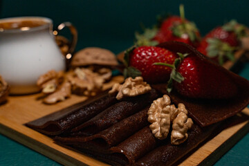 Delicious dessert in a wooden plate with walnuts, strawberries and traditional Turkish coffee on top