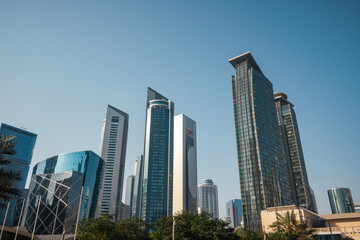Fototapeta premium Bottom view of skyscrapers and tall buildings in Doha, Qatar with wide angle sky