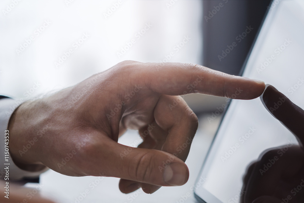 Poster close detail of a man's finger making contact with the screen of a sleek digital tablet resting on a