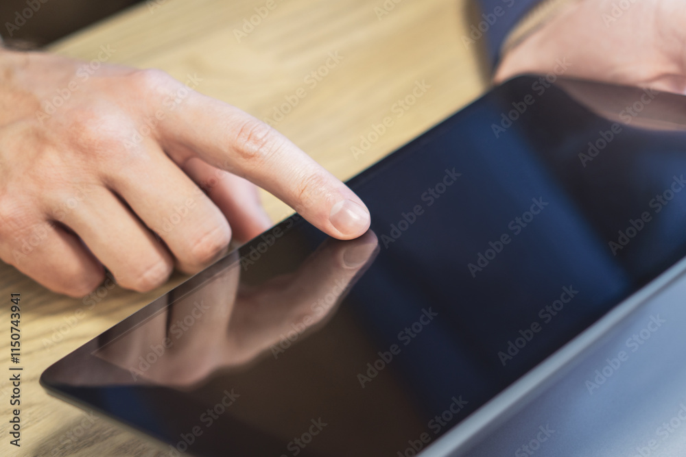 Poster male finger engaging with a cutting-edge digital tablet on a desk, set within the unfocused hustle o