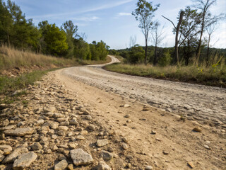 Naklejka premium dirt road in the countryside. road, landscape, sky, nature, field, tree, country, grass, rural, path, summer, trees, green, countryside, asphalt, hill, lane, forest, clouds, dirt, travel, horizon, gra