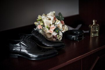 Elegant Wedding Preparations: Classic Black Shoes, Bridal Bouquet, and Accessories