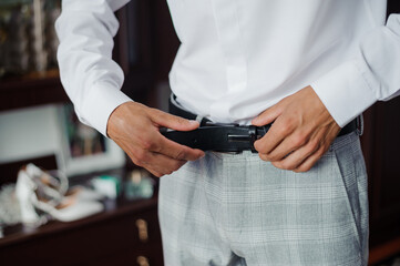 Groom Adjusting Belt Before Wedding Ceremony