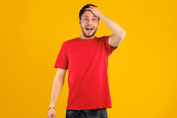 Omg, Wow. Portrait of young shocked handsome guy with open mouth holding hand on his head, looking at camera in amazement and with surprised facial expression, standing isolated over blue background