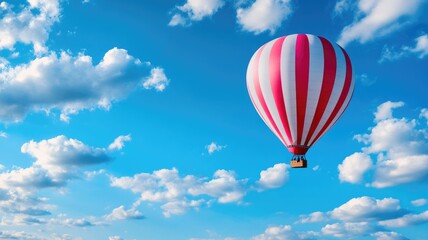Naklejka premium Red-and-white hot air balloon in blue sky with clouds
