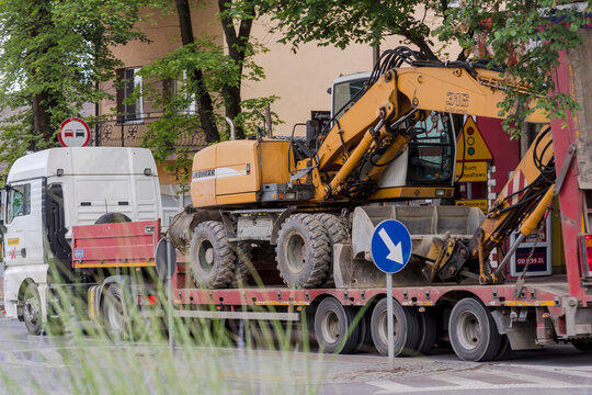 Polska Ostrowiec Świętokrzyski 2 lipca 2024 14:49 Transport na lawecie koparki kołowej LIEBHERR. Duża niemiecka ż&oacute;łta koparka transportowana ciężar&oacute;wką na plac budowy drogi.
