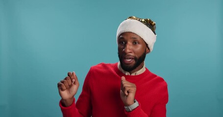 Christmas dance, face or man in studio with party, celebration or smile on blue background. African person, portrait or excited model with humor, sales discount or event with joy, Xmas hat or winner
