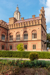 A large brick building with a tall tower and a cross on top