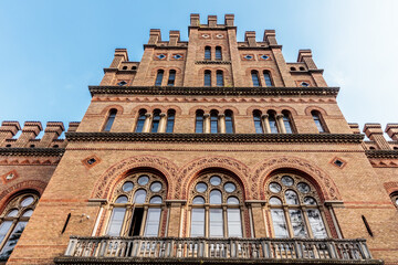 Fototapeta premium A large brick building with arched windows and a balcony