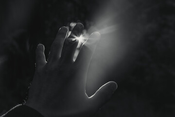 A hand reaching out to the sun.