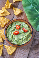 Guacamole with Tortilla Chips on Rustic Wooden Table with Leaf