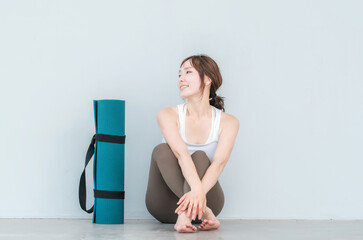 Fototapeta premium ヨガウェア・スポーツウェアを着た女性とヨガマット 