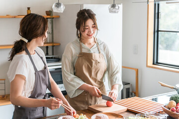料理教室・クッキングスクールで料理を教える講師の女性と生徒の女性
