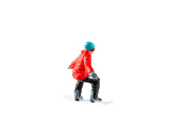 Miniature figurine depicting a snowboarder in mid-motion isolate on white background with clipping path