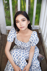 Asian beauty taking photos on the balcony of the villa in midsummer