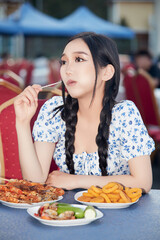 Beautiful woman eating a lot at an outdoor buffet