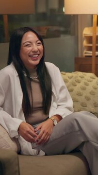 Happy, asian woman or social with talking circle on sofa for communication, conversation or equality at home. Female person, interaction and pass with expandable breathing ball for speech therapy