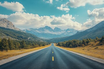 Fototapeta premium Scenic mountain road stretching towards distant peaks under a partly cloudy sky.