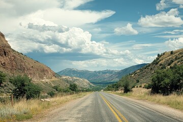 Fototapeta premium Scenic highway through mountain valley under a partly cloudy sky.