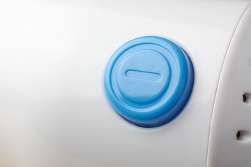 close-up of blue round button of a device or machinery on white surface background, control panel...