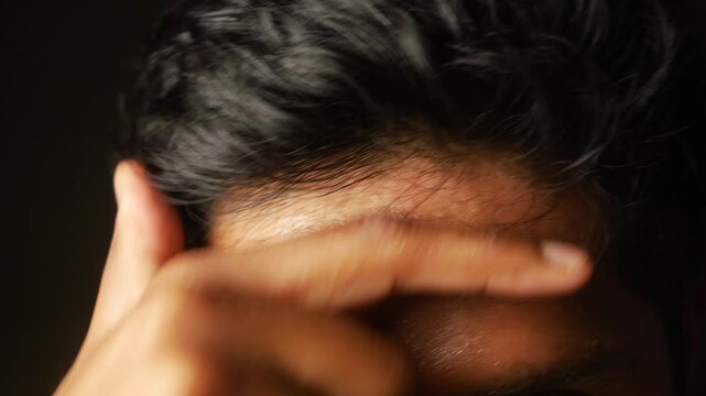 closeup of sweat on forehead against dark background ,