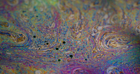 Rainbow curve. Acrylic slick. Defocused multicolor purple green liquid oil paint curve acrylic on dark black blurred light abstract art background.