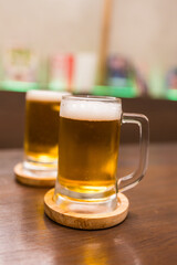 Close up shot of beer two glasses of beer on a wooden table