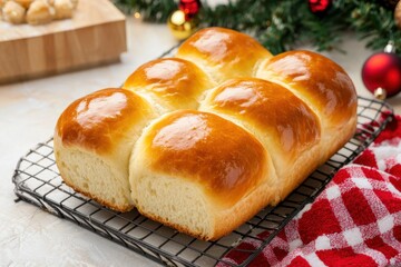 A freshly baked loaf of soft, golden dinner rolls on a cooling rack, surrounded by festive decorations, perfect for holiday gatherings.