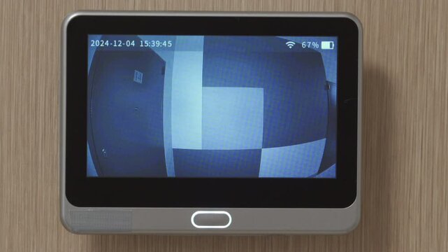 Apartment front door peep hole camera motion detector. looking at screen of digital door peephole viewer.