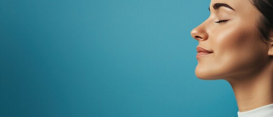 mindful living awareness concept. A serene portrait of a woman with closed eyes, showcasing a peaceful expression against a vibrant blue background.