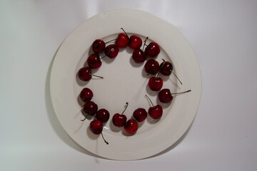 Red fresh cherries on a big white plate