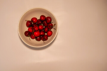 Red fresh cherries in a small white bowl