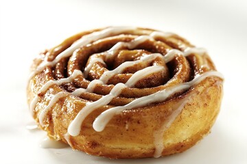 Fototapeta premium single cinnamon roll with golden-brown swirl and drizzle of white icing displayed on crisp white background