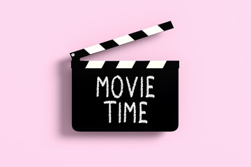 Fototapeta premium Movie time clapperboard on pink background symbolizing entertainment