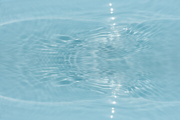 Blue water with ripples on the surface. Defocus blurred transparent blue colored clear calm water surface texture with splashes and bubbles. Water waves with shining pattern texture background.