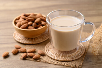 Almond milk in cup glass on wooden table, Alternative milk made from plant, non dairy