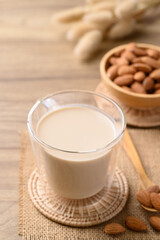 Almond milk in cup glass on wooden table, Alternative milk made from plant, non dairy