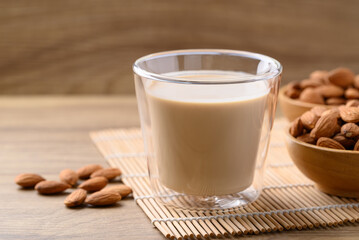 Almond milk in cup glass on wooden table, Alternative milk made from plant, non dairy
